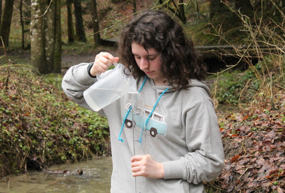 Eine Schülerin misst die Transparenz eines Fliessgewässers