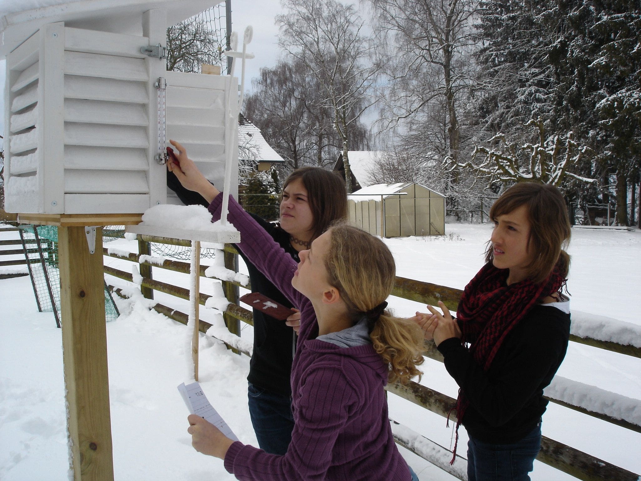 SchülerInnen lesen Messwerte an den Geräten in ihrem Wetterhaus ab.