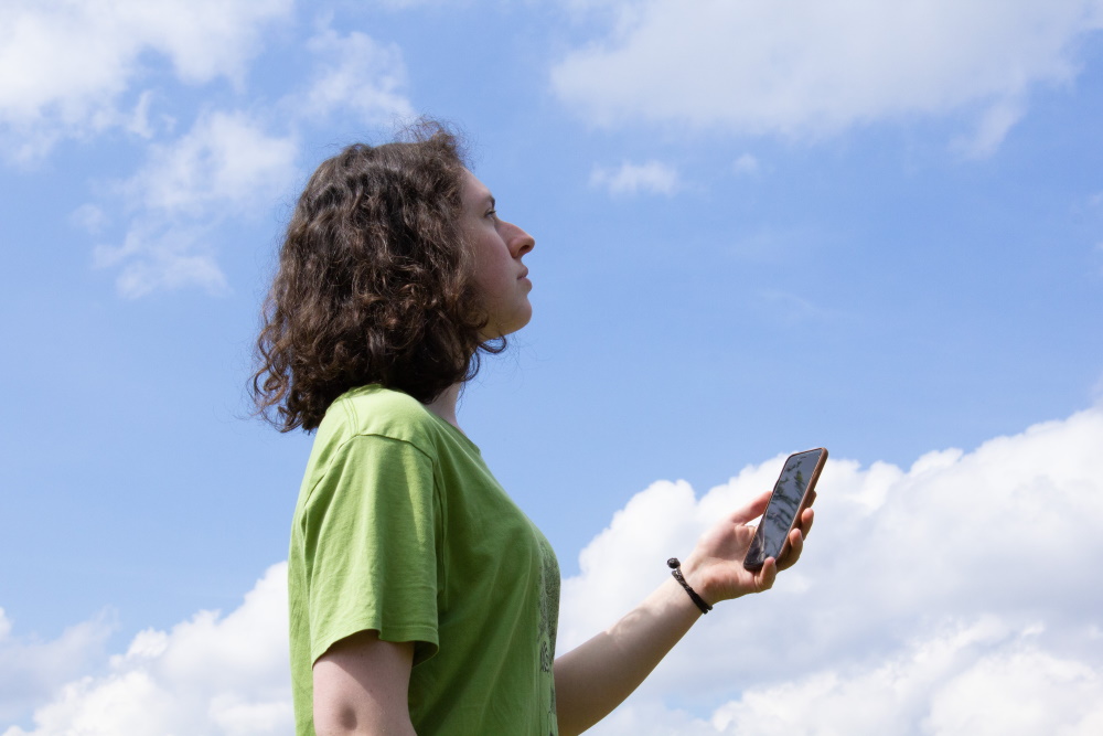 Eine Schülerin beobachtet den Himmel mit der GLOBE Observer App